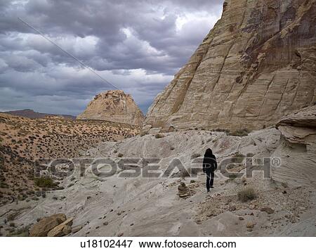 Stock Photo - Woman walking on rocks, Utah, USA. Fotosearch