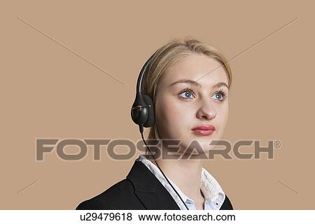 Beautiful female customer service representative over colored background View Large Photo Image Stock Photo - Beautiful female customer service representative over colored background. Fotosearch