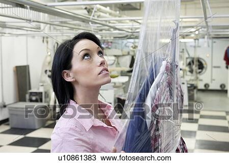 Stock Image - Beautiful woman looking up in laundry. Fotosearch
