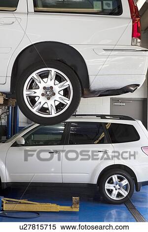 Car on hoist in automobile repair shop View Large Photo Image Stock Photography - Car on hoist in automobile repair shop. Fotosearch