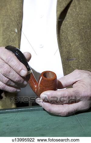 Stock Image - Close-up view of owner holding tobacco pipe. Fotosearch