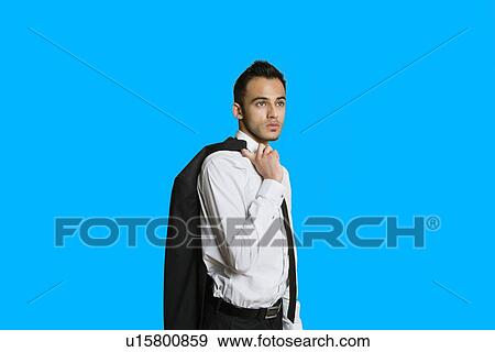 Stock Photo - Confident young businessman with suit over shoulder on colored background. Fotosearch