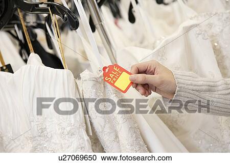 Cropped shot of female hands holding price tag attached to wedding gown in bridal boutique View Large Photo Image Stock Image - Cropped shot of female hands holding price tag attached to wedding gown in bridal boutique. Fotosearch