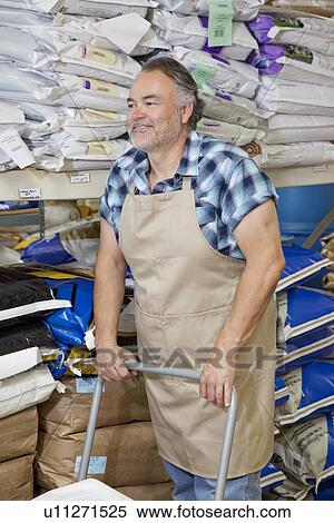 Happy mature man pushing cart in feed store View Large Photo Image Stock Photography - Happy mature man pushing cart in feed store. Fotosearch