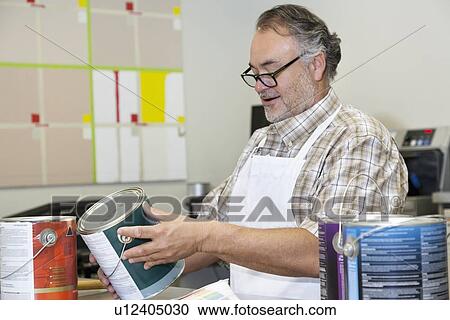 Happy mature sales clerk reading instructions paint can in hardware store View Large Photo Image Stock Image - Happy mature sales clerk reading instructions paint can in hardware store. Fotosearch