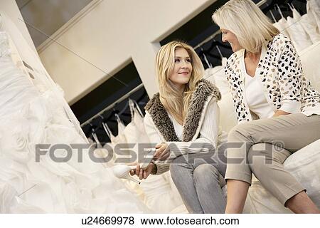 Happy mother and daughter sitting footwear in bridal store View Large Photo Image Stock Photo - Happy mother and daughter sitting footwear in bridal store. Fotosearch