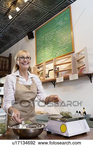 Happy senior merchant measuring ingredient on weight scale in spice store View Large Photo Image Stock Image - Happy senior merchant measuring ingredient on weight scale in spice store. Fotosearch