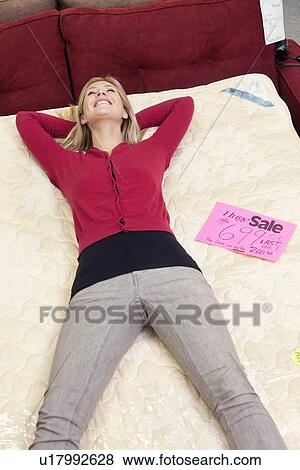 High angle view of woman relaxing on mattress in furniture store View Large Photo Image Stock Photo - High angle view of woman relaxing on mattress in furniture store. Fotosearch