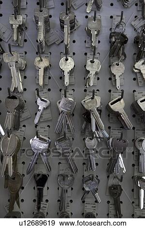 Stock Photo - Large group of keys hanging on hooks in store. Fotosearch