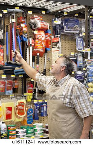 Stock Image - Mature salesperson working in hardware store. Fotosearch
