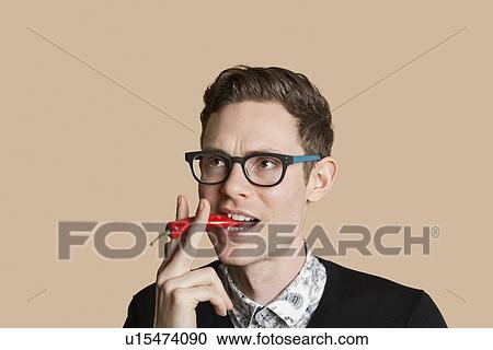 Mid adult man smoking red chili pepper over colored background View Large Photo Image Stock Image - Mid adult man smoking red chili pepper over colored background. Fotosearch