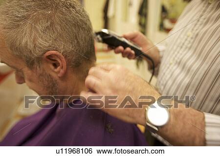 Midsection of senior barber giving haircut to customer in salon View Large Photo Image Stock Photograph - Midsection of senior barber giving haircut to customer in salon. Fotosearch