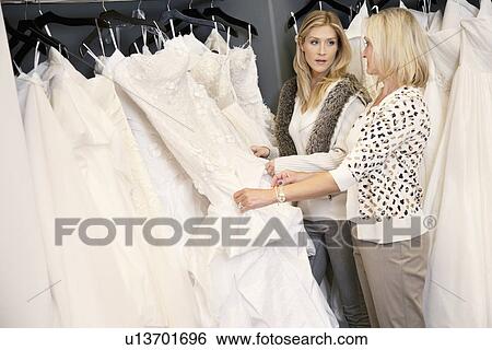 Mother and daughter looking at each other while selecting wedding gown in bridal store View Large Photo Image Stock Photograph - Mother and daughter looking at each other while selecting wedding gown in bridal store. Fotosearch