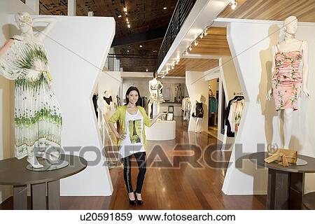 Portrait of a beautiful mid adult woman standing with mannequins in fashion boutique View Large Photo Image Stock Photo - Portrait of a beautiful mid adult woman standing with mannequins in fashion boutique. Fotosearch