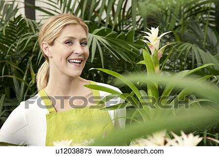 Stock Photography - Portrait of a cheerful young woman in garden. Fotosearch
