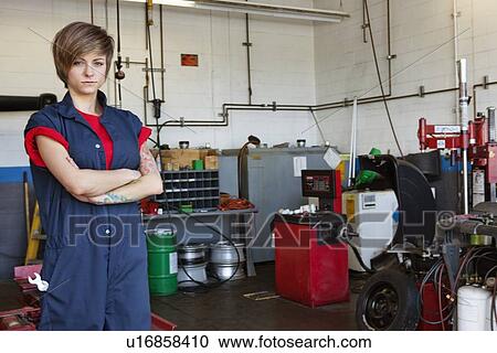 Portrait of a confident young female mechanic with arms crossed in garage View Large Photo Image Stock Image - Portrait of a confident young female mechanic with arms crossed in garage. Fotosearch