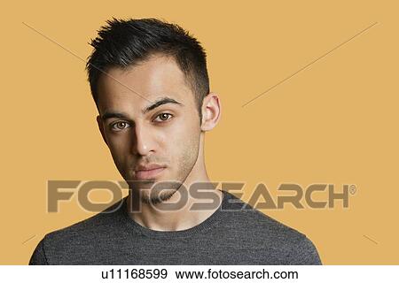 Portrait of a confident young man over colored background View Large Photo Image Stock Photo - Portrait of a confident young man over colored background. Fotosearch