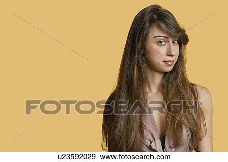 Stock Photo - Portrait of a confident young woman over colored background. Fotosearch