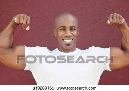Portrait of a happy African American man flexing muscles over colored background View Large Photo Image Stock Photography - Portrait of a happy African American man flexing muscles over colored background. Fotosearch