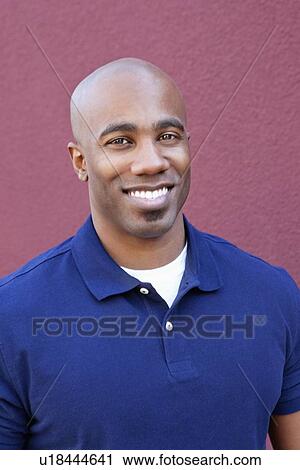 Portrait of a happy bald African American male over colored background View Large Photo Image Stock Image - Portrait of a happy bald African American male over colored background. Fotosearch
