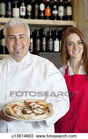 Portrait of a happy chef holding pizza with beautiful waitress View Large Photo Image Stock Image - Portrait of a happy chef holding pizza with beautiful waitress. Fotosearch