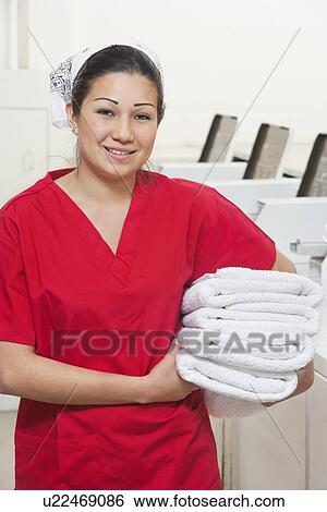 Portrait of a happy female employee in red uniform holding towel View Large Photo Image Stock Photograph - Portrait of a happy female employee in red uniform holding towel. Fotosearch