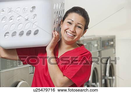 Portrait of a happy female employee carrying laundry basket View Large Photo Image Stock Photograph - Portrait of a happy female employee carrying laundry basket. Fotosearch