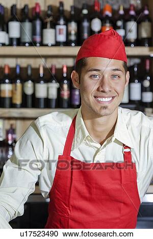 Stock Image - Portrait of a happy handsome young bartender. Fotosearch