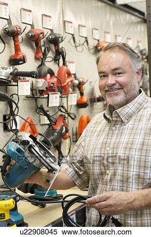 Portrait of a happy hardware store owner with electric saw View Large Photo Image Stock Photography - Portrait of a happy hardware store owner with electric saw. Fotosearch