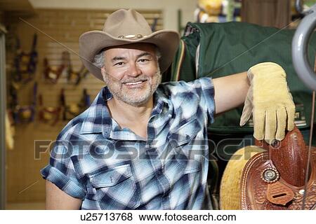 Portrait of a happy mature cowboy in feed store View Large Photo Image Stock Photo - Portrait of a happy mature cowboy in feed store. Fotosearch