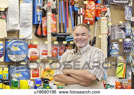 Portrait of a happy mature salesperson with arms crossed in hardware store View Large Photo Image Stock Photograph - Portrait of a happy mature salesperson with arms crossed in hardware store. Fotosearch