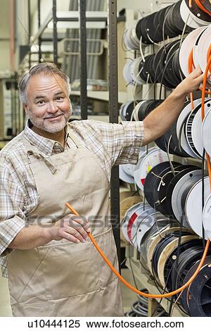 Portrait of a happy mature store clerk with electrical wire spool in hardware shop View Large Photo Image Stock Photography - Portrait of a happy mature store clerk with electrical wire spool in hardware shop. Fotosearch