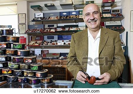 Portrait of a happy mature tobacco shop owner with cans on display View Large Photo Image Stock Image - Portrait of a happy mature tobacco shop owner with cans on display. Fotosearch
