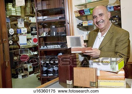 Portrait of a happy owner showing cigar boxes in store View Large Photo Image Stock Photography - Portrait of a happy owner showing cigar boxes in store. Fotosearch