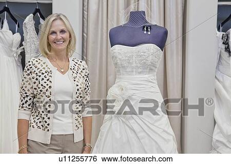 Stock Photograph - Portrait of a happy senior bridal store owner. Fotosearch