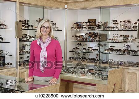 Portrait of a happy senior female optician standing in store View Large Photo Image Stock Image - Portrait of a happy senior female optician standing in store. Fotosearch