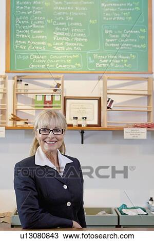 Stock Image - Portrait of a happy senior spice store owner. Fotosearch