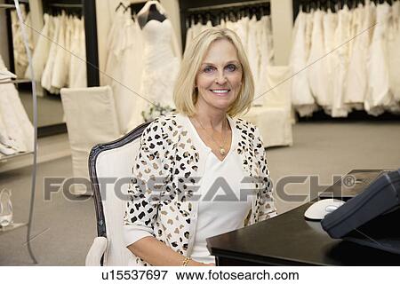 Portrait of a happy senior woman sitting in bridal store View Large Photo Image Stock Photo - Portrait of a happy senior woman sitting in bridal store. Fotosearch