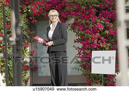 Portrait of a happy senior woman standing with clipboard View Large Photo Image Stock Photo - Portrait of a happy senior woman standing with clipboard. Fotosearch