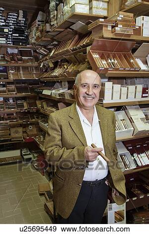 Portrait of a happy standing in front of cigar display View Large Photo Image Stock Photo - Portrait of a happy standing in front of cigar display. Fotosearch