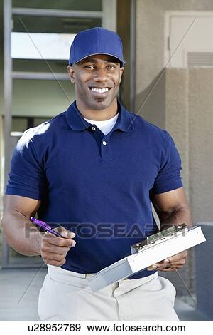 Portrait of a happy young African American delivery man with clipboard View Large Photo Image Stock Photo - Portrait of a happy young African American delivery man with clipboard. Fotosearch