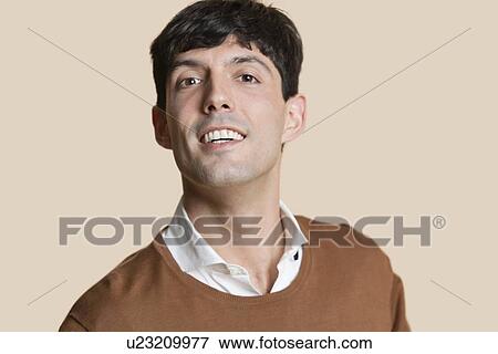 Stock Photo - Portrait of a happy young man over colored background. Fotosearch