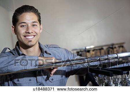 Portrait of a happy young man standing in fashion boutique View Large Photo Image Stock Image - Portrait of a happy young man standing in fashion boutique. Fotosearch