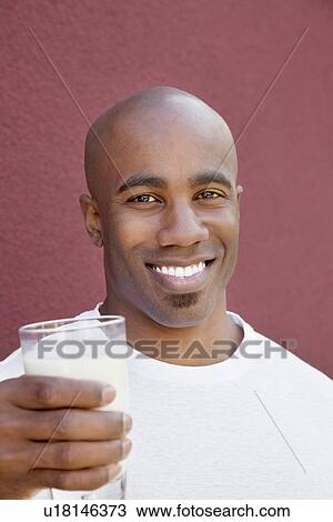 Portrait of a happy young man with milk glass over colored background View Large Photo Image Stock Image - Portrait of a happy young man with milk glass over colored background. Fotosearch