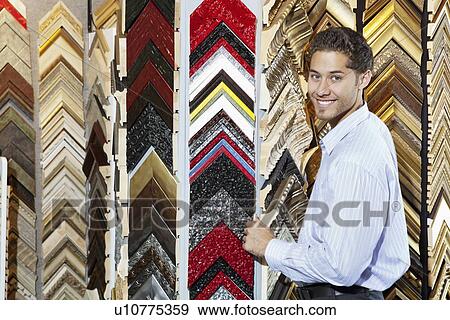 Portrait of a happy young man with multi colored frames in background View Large Photo Image Stock Photo - Portrait of a happy young man with multi colored frames in background. Fotosearch