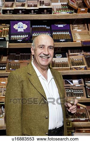 Portrait of a male owner of tobacco shop standing with cigar boxes in background View Large Photo Image Stock Image - Portrait of a male owner of tobacco shop standing with cigar boxes in background. Fotosearch