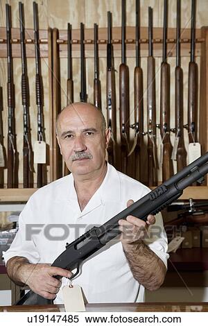 Portrait of a mature gun merchant with rifle View Large Photo Image Stock Photography - Portrait of a mature gun merchant with rifle. Fotosearch