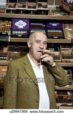 Portrait of a mature man smoking cigar in tobacco store View Large Photo Image Stock Photography - Portrait of a mature man smoking cigar in tobacco store. Fotosearch