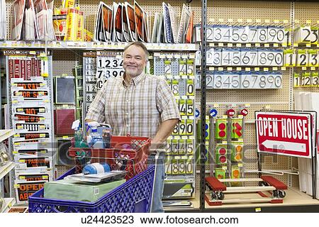 Portrait of a mature man with shopping cart in hardware store View Large Photo Image Stock Image - Portrait of a mature man with shopping cart in hardware store. Fotosearch