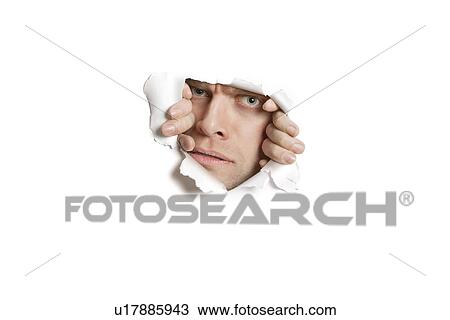 Portrait of a mid adult Caucasian man peeking from ripped white paper hole View Large Photo Image Stock Image - Portrait of a mid adult Caucasian man peeking from ripped white paper hole. Fotosearch